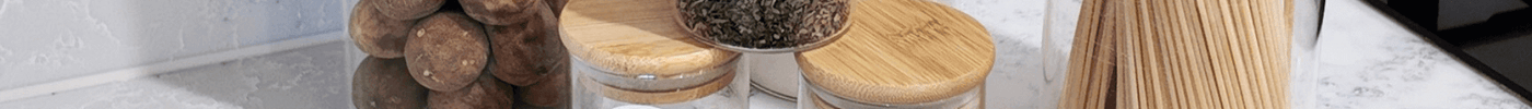 Pantry storage jars with labels for rock salt, flour, and spaghetti on kitchen counter.