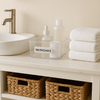 Clear skincare organiser on bathroom counter with towels and woven baskets, promoting home organisation.