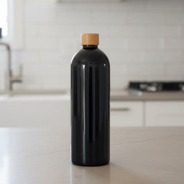 Black bottle with a bamboo cap on a white background
