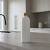 White bottle with a gold cap on a bathroom counter