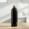 Black bottle with a wooden cap on a kitchen counter