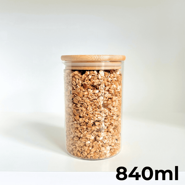 Round glass bamboo lid storage jar 840ml filled with granola, ideal for pantry use.