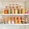 Round glass storage jars with bamboo lids, perfect for pantry organization and space-saving.