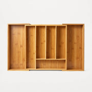 Wooden drawer organizer with multiple compartments on a white background