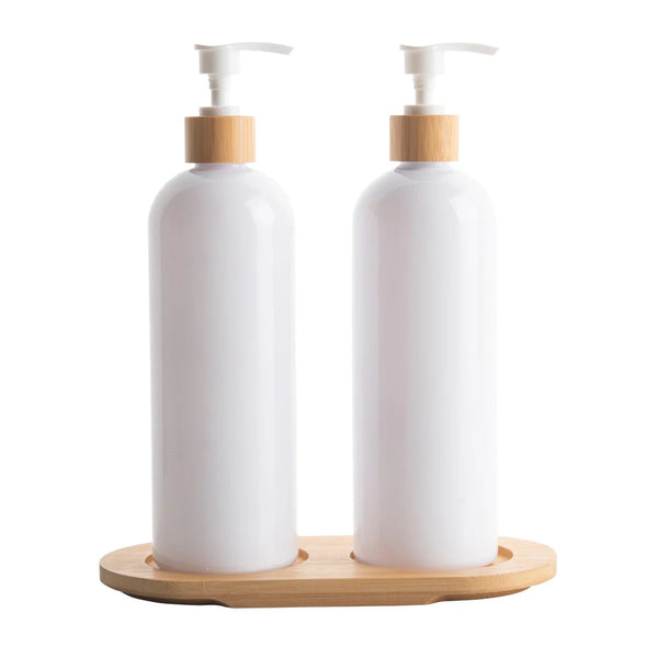 Two white bottles with bamboo caps on a wooden stand against a white background