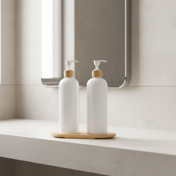 Two white bottles with bamboo caps on a wooden stand against a white background