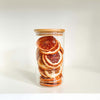 Round bamboo glass jar storing dried oranges for pantry organization and space-saving