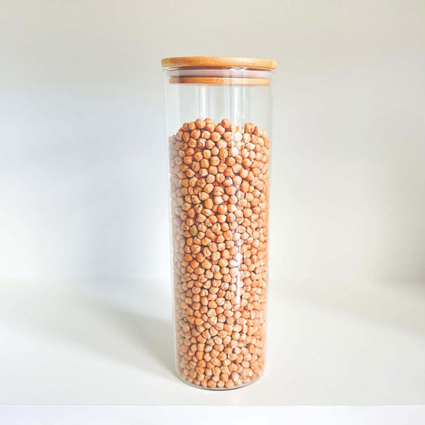 Tall round glass pantry jar with bamboo lid, ideal for chickpea storage and pantry organization.