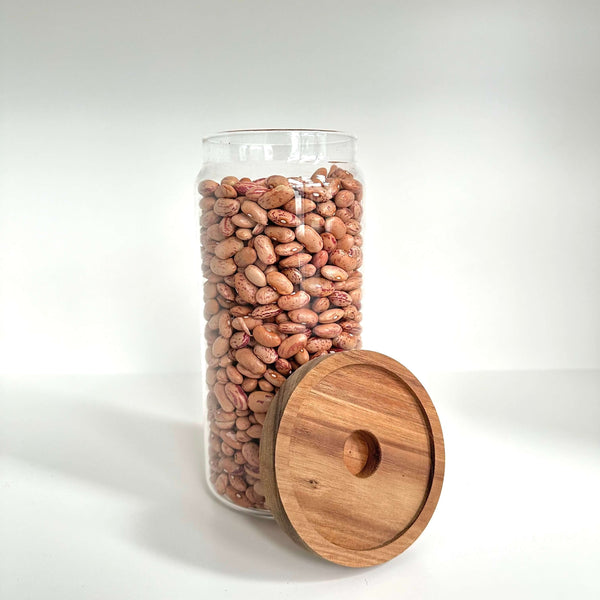 Round glass storage jar with acacia lid, filled with beans; ideal for pantry organization.