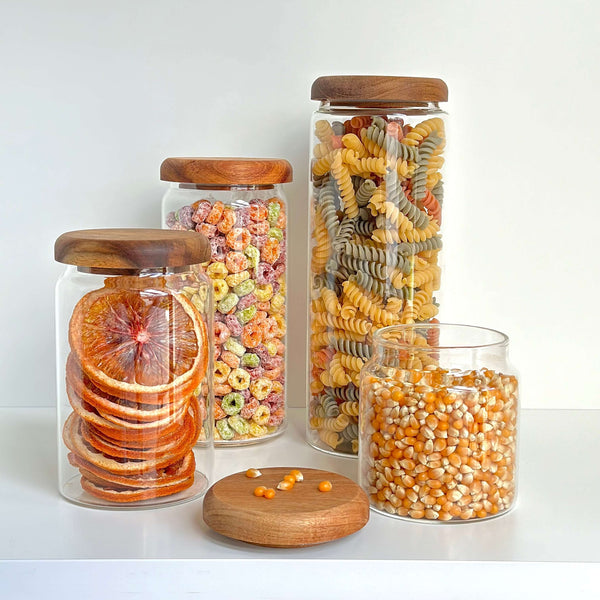 Glass jars with acacia lids for pantry organization, filled with dried goods. Ideal storage organiser, kitchen baskets.