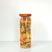 Clear glass jar with acacia lid filled with multicoloured pasta, ideal for Acacia Lid Glass Jar Small Pantry Organisation 15 Pack in kitchen.