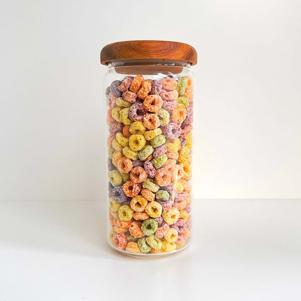 Glass jar with acacia lid filled with cereal, ideal for pantry storage organization.