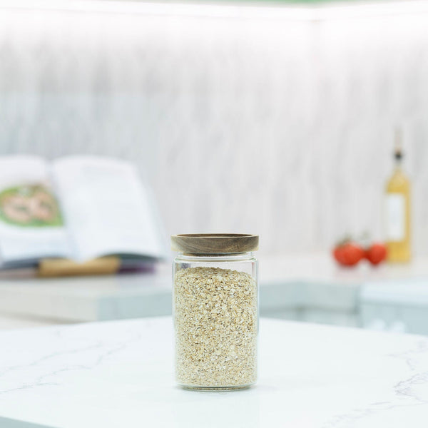 Round Glass Acacia Storage Jar with lid on kitchen counter, ideal for pantry organisation, part of 5 Pack storage organisers set.