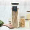 Hand holding Square Acacia Lid Glass Jar filled with pasta, ideal for kitchen or pantry organisation and storage organisers.
