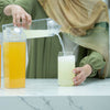 Pouring drink into Bamboo Glass Drinking Jar Set – 500ml with Straws, ideal for kitchen or pantry organisation with glass jars.
