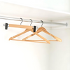 Bamboo coat hangers with black matte hooks for home organisation in a closet; ideal for space-saving and stylish storage solutions.