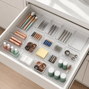 Clear drawer organiser trays neatly arranged in a bathroom drawer with makeup, hair ties and everyday essentials