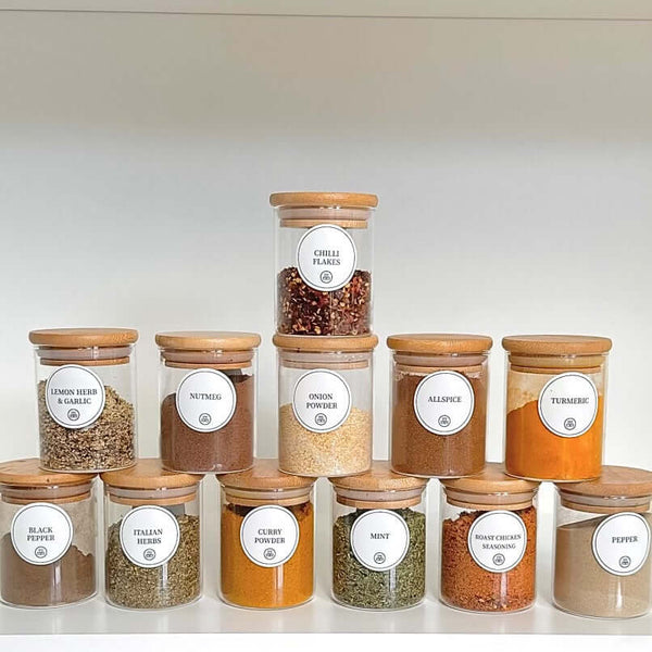 Round glass bamboo herb and spice storage jars set on pantry shelf, space-saving kitchen organiser.