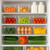 Organised fridge with clear containers, fruits, vegetables, showcasing home storage solutions.