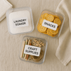 Labeled storage containers for home organization: laundry soaker, snacks, craft supplies.