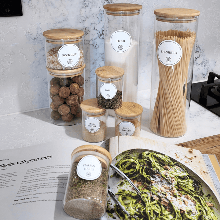 Pantry storage jars with labels for rock salt, flour, and spaghetti on kitchen counter.