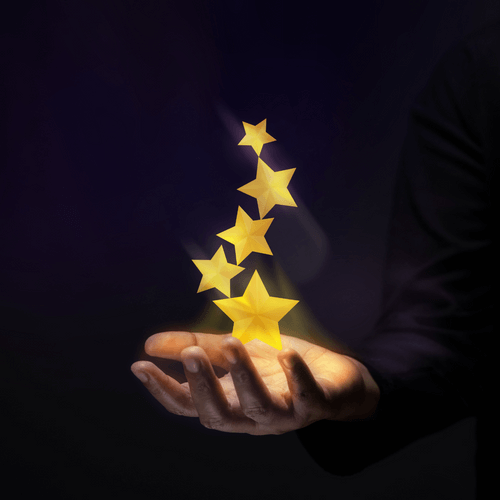 Hand holding glowing stars representing rewards and achievements in home organisation.