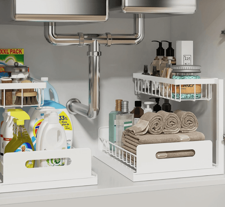 Under-sink storage with organised cleaning supplies and toiletries in sliding drawers.
