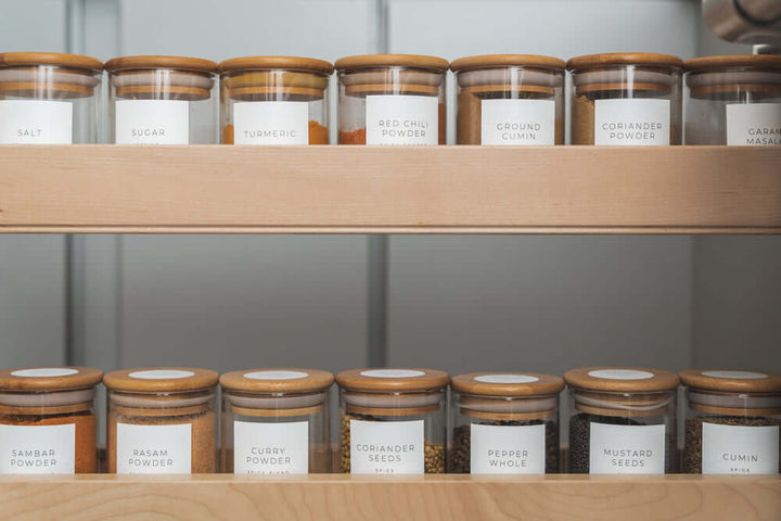 Organised spice jars on wooden pantry shelves for efficient home organisation and pantry storage.