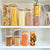 Square bamboo glass pantry storage containers with various dry foods, ideal for kitchen organization.