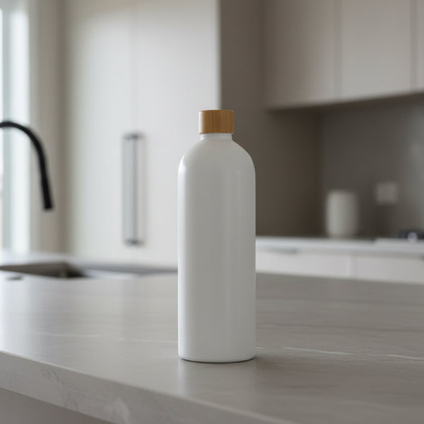 White bottle with a gold cap on a bathroom counter