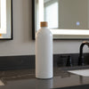 White bottle with a wooden cap on a bathroom counter