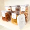 White airtight containers with twist lock for kitchen storage, featuring pasta, beans, and cereal. Ideal for home organization, pantry storage.