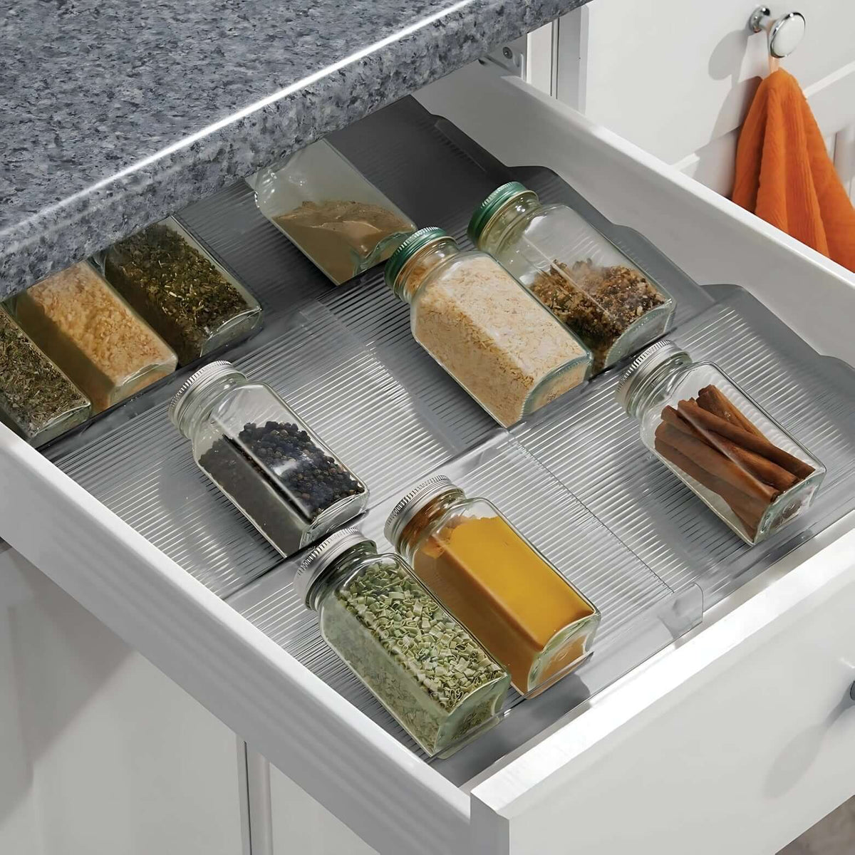 Expandable In-Drawer Spice Rack neatly organising glass jars for efficient kitchen and pantry storage.