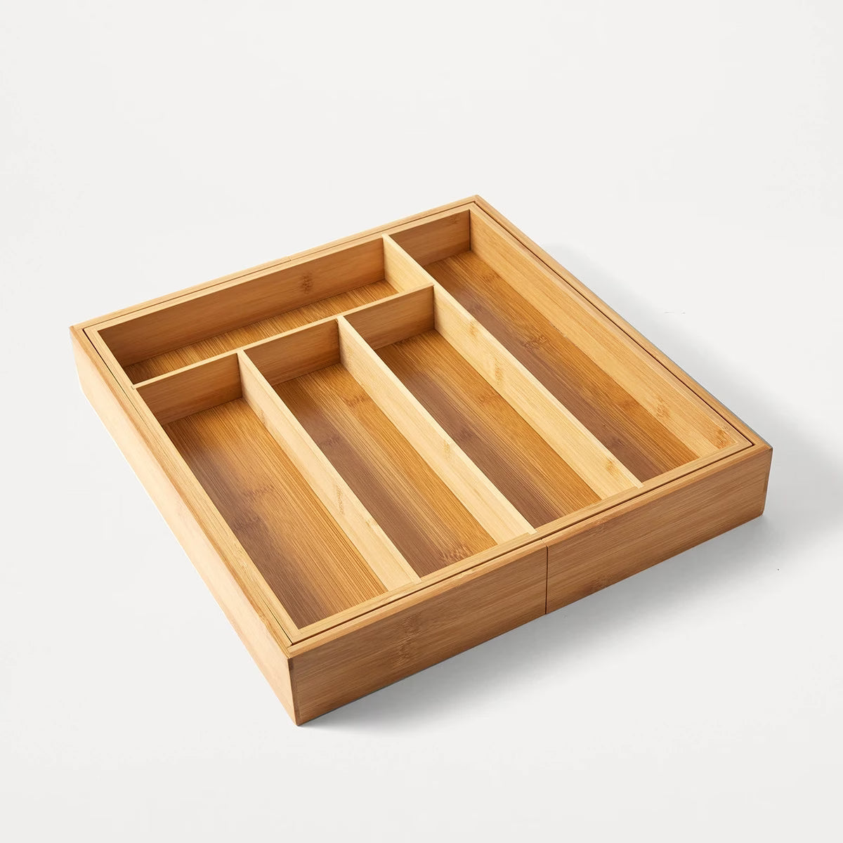 Wooden drawer organizer with compartments on a white background