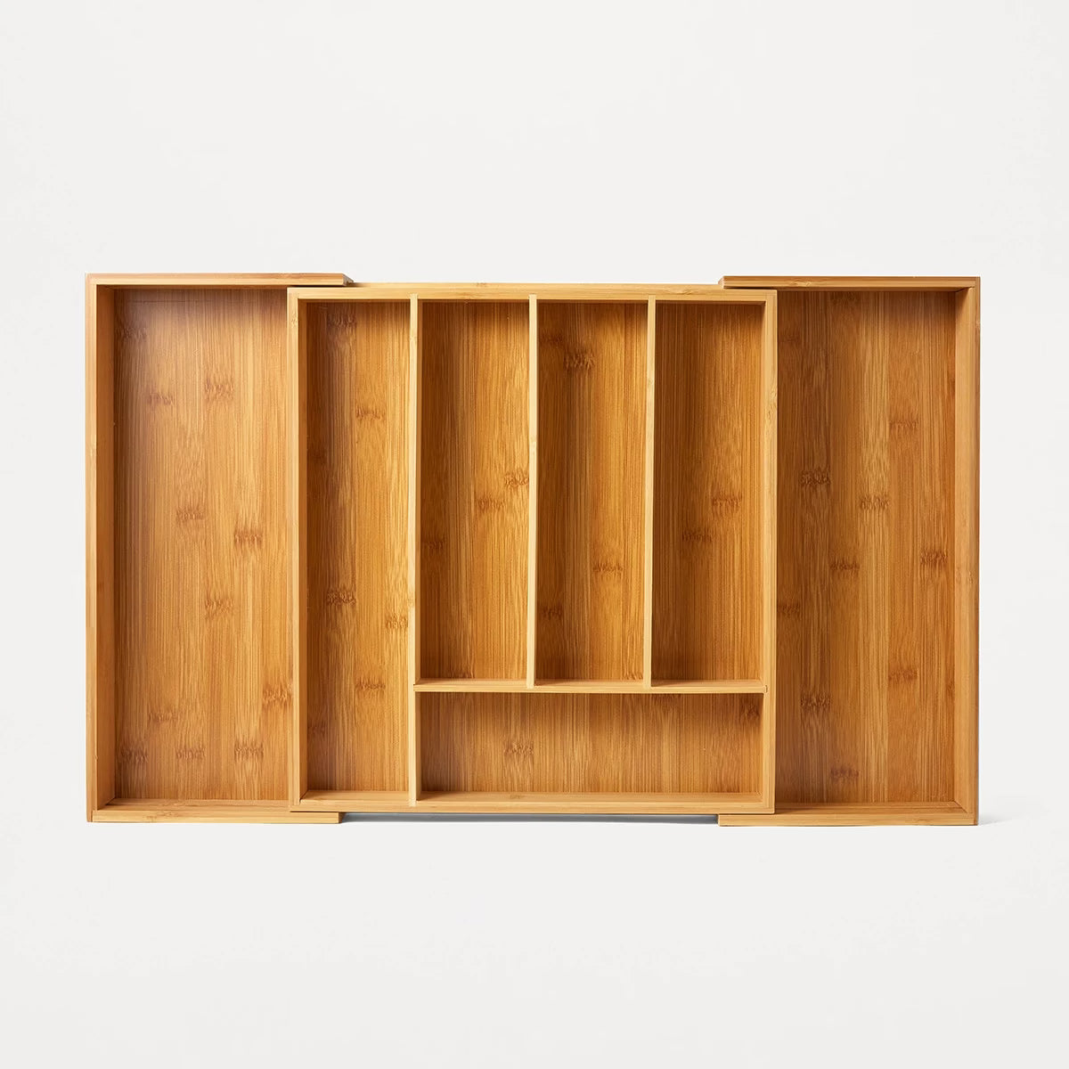 Wooden drawer organizer with multiple compartments on a white background