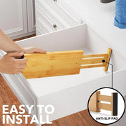 Person installing Bamboo Expandable Drawer Dividers – 4 Pack (Long) for efficient kitchen drawer organisation.