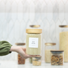 Hand holding a jar labeled 'Raw Sugar' with blurred jars in the background