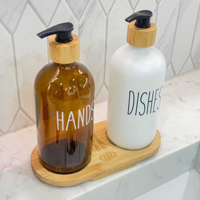 Bamboo Tray for Round Bottles – 500 ml holding soap dispensers on a bathroom counter, ideal for kitchen and pantry organisation.