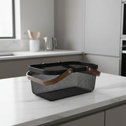 Black Mesh Large Handy Storage Basket – Acacia Handle placed on a kitchen counter, perfect for pantry or under sink organisation.