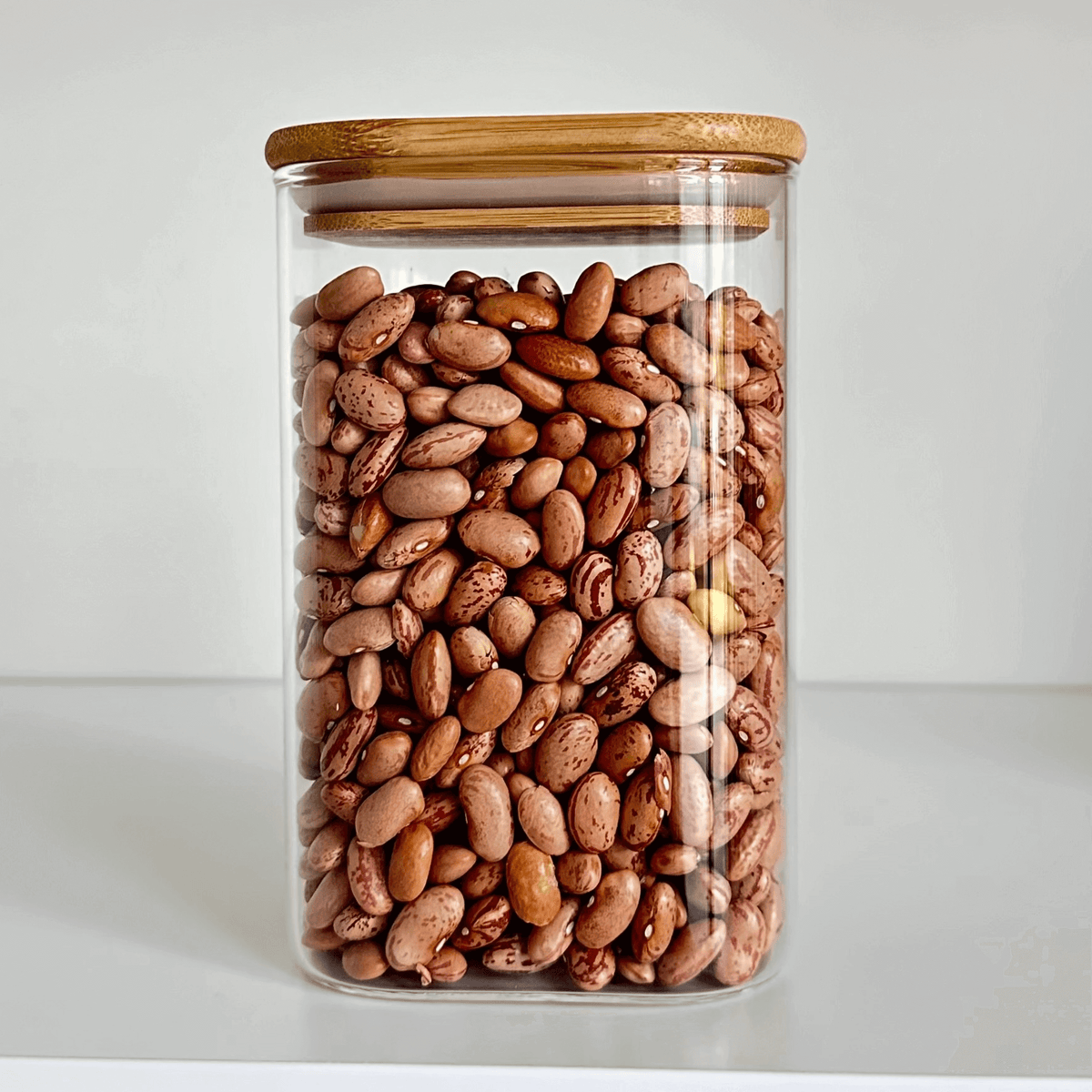 Square Bamboo Glass Pantry Jar Set – 5 Stackable Sizes with pinto beans for kitchen organisation and pantry storage.