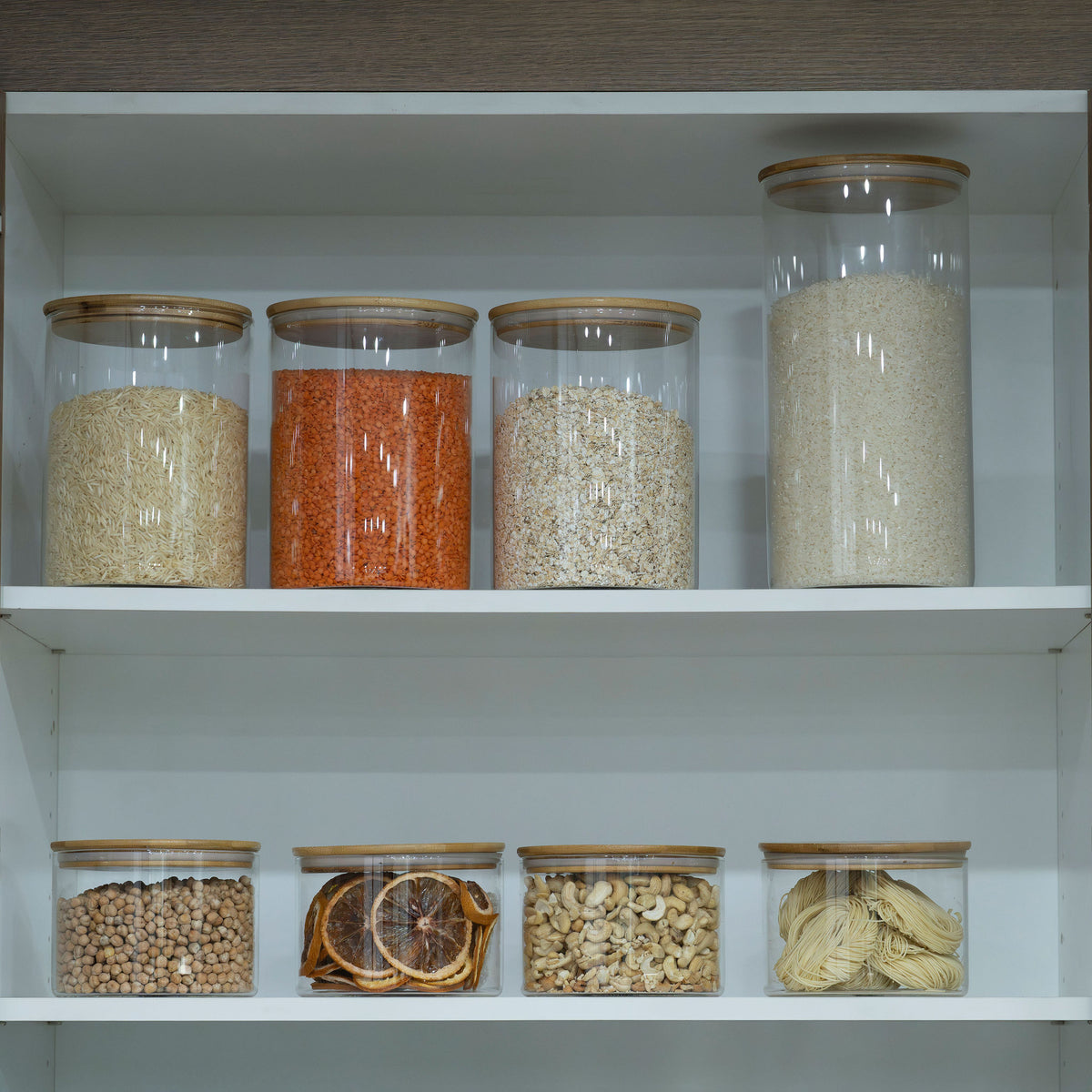 Glass jars on a shelf with grains and legumes, ideal for pantry organisation in a New Home Set Up Pack. Enhances kitchen storage.