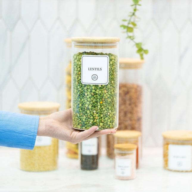 Person holding 1400ml Round Glass Storage Jar with Bamboo Lid for pantry organisation, perfect for storing lentils in the kitchen.