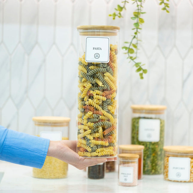 Person holding 2100ml Glass Storage Jar with Bamboo Lid filled with pasta, ideal for kitchen and pantry organisation.