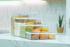 Set of clear airtight stackable pantry containers in multiple sizes, stacked on a marble benchtop and filled with pasta, grains, nuts and snacks