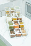 Top view of clear stackable pantry containers arranged in a grid, storing pasta, rice, lentils, nuts and biscuits