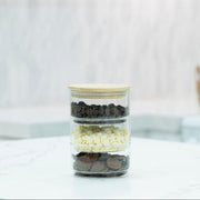 Stackable Round Bamboo Glass Jar – 450ml filled with chocolate chips on kitchen counter; ideal for pantry organisation and storage.