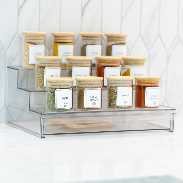 Three-tier clear herb & spice rack with drawer for kitchen organisation, featuring labelled glass jars. Ideal for pantry storage.