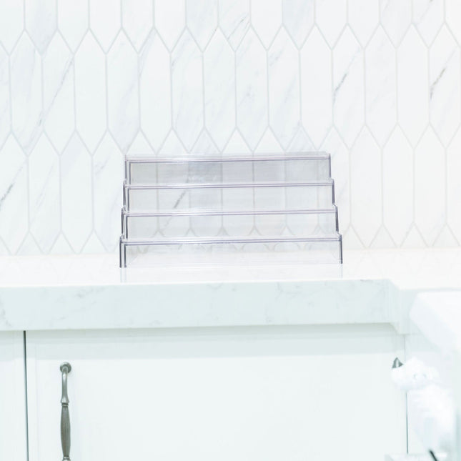 Expandable 4-Tier Clear Spice Rack Organiser on a kitchen counter for pantry organisation, ideal for storage of glass jars.