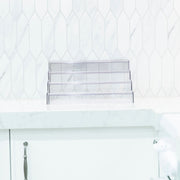 Expandable 4-Tier Clear Spice Rack Organiser on a kitchen counter for pantry organisation, ideal for storage of glass jars.
