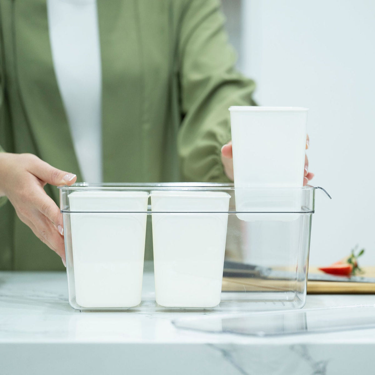 Person using Triple Clear Fridge Organiser with Removable Baskets for efficient kitchen organisation on a countertop.
